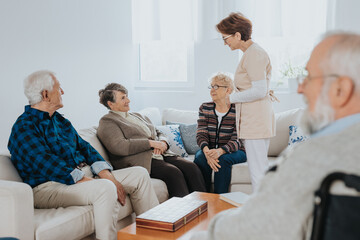 Wall Mural - Head nurse is talking to new patients sitting on the sofa in a retirement home