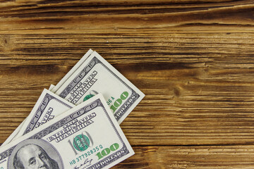 Wall Mural - Stack of one hundred dollars bills on wooden desk