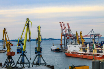 Hoisting cranes and industrial ships at cargo sea port in Odessa, Ukraine