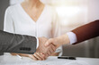 © rogerphoto - Business people shaking hands finishing contract signing in sunny office, close-up. Handshake and marketing
