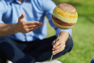 Wall Mural - close up of unrecognizable male teacher pointing at planet model during outdoor class in sunlight, c