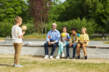 Wall Mural - full length portrait of smiling male teacher listening to boy giving presentation on astronomy while