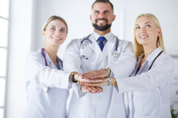 Wall Mural - Doctors and nurses in a medical team stacking hands