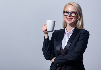 Poster - Beautiful blonde businesswoman in suit with cup of coffee