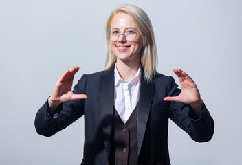 Poster - Beautiful blonde businesswoman in suit on gray background