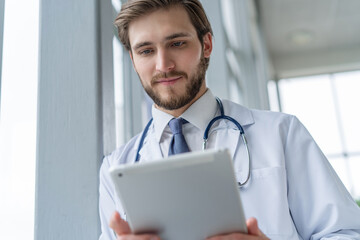 Wall Mural - male medical doctor using tablet computer in hospital.