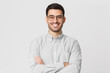 © Damir Khabirov - Smiling handsome man in shirt and round glasses standing with crossed arms isolated on gray