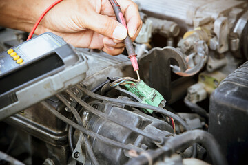 Auto mechanic checking electrical system in a car engine concepts of maintenance repair service and car insurance.