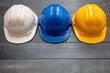© Rawf8 - Industrial protective hard hats on blue wooden background.