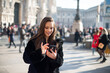 © Minerva Studio - Woman using her smartphone while walking in a city