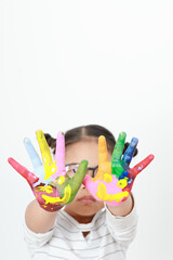 Asian little girl wearing glasses looking show two hands with watercolor.