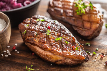 Wall Mural - Close up view of freshly roasted duck breasts with pepper seasoning and fresh herbs on top