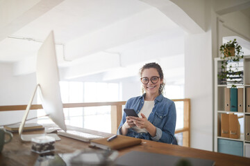 Portrait of modern young woman wearing glasses and smiling at camera while sitting at workplace in white office, female IT developer concept, copy space