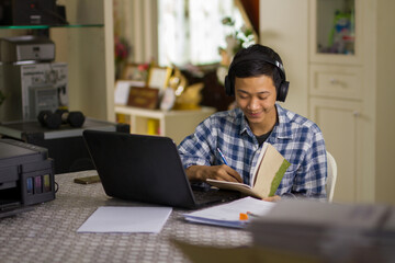 Teenage of asian people writing a note while learning from online lesson at home. studying at home and self study concept