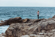 © phpetrunina14 - young woman in coat at seaside looking at storming sea