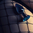 Close-up of anal plug sexy device with blue crystal on the female ass in pantyhose in the fishnet