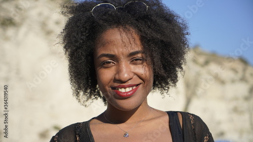 Cuadros en Lienzo Portrait of african american female wearing bikini standing outdoors along the b