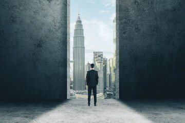 Canvas Print - Businessman stands in the doorway and looking on modern city