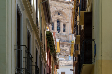 Tower of the cathedral of Granada seen from the narrow Sillería street