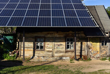 Solar Panels Over Old Dilapidated Wooden House