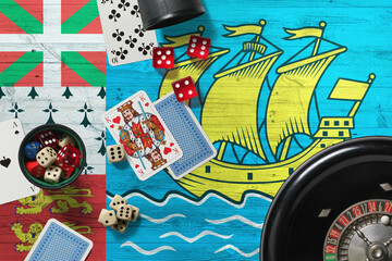 Wall Mural - Saint Pierre And Miquelon casino theme. Aces in poker game, cards and chips on red table with national wooden flag background. Gambling and betting.