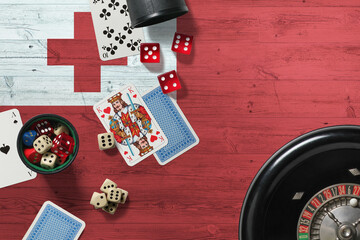 Wall Mural - Tonga casino theme. Aces in poker game, cards and chips on red table with national wooden flag background. Gambling and betting.