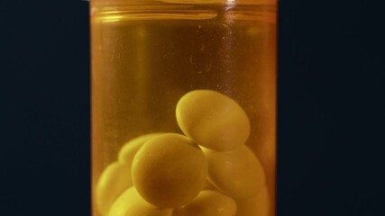 Wall Mural - Orange pill bottle with tablets on dark background, macro shot. Medication tablets, drugs and supplements