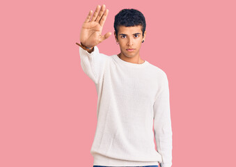 Young african amercian man wearing casual clothes doing stop sing with palm of the hand. warning expression with negative and serious gesture on the face.