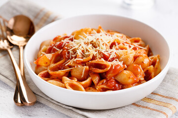 Pasta conchiglie with tomato sauce and parmesan cheese