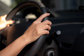 Close-up of female hands on steering wheel while driving a car