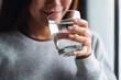 © Farknot Architect - Closeup image of a beautiful young asian woman holding a glass of water to drink