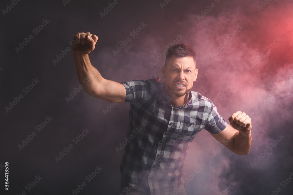 Protesting aggressive man on dark background