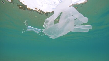 Wall Mural - Disposable gloves and face mask underwater, plastic waste pollution in the ocean since coronavirus COVID-19 pandemic