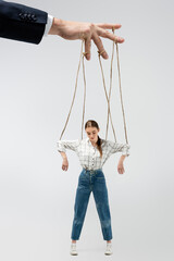 cropped view of puppeteer holding marionette on strings isolated on grey