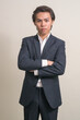 © Ranta Images - Portrait of young Filipino businessman in suit with arms crossed