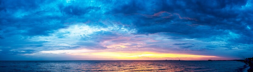 Wall Mural - Beautiful sunset with colored clouds over the sea