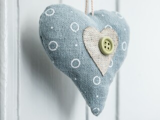 Poster - Closeup shot of a heart-shaped object made of a button and circle-patterned fabric