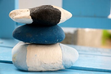 Wall Mural - Closeup of stacked stones on a wooden table with a blurry background - concept of zen energy