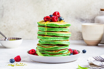 Poster - Matcha tea pancakes with berries, white background. Healthy vegan food concept.