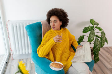 Wall Mural - Woman reading newspapers and having breakfast