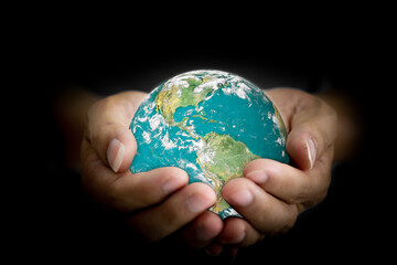 Canvas Print - environment concept. earth with light in human hand on black background. elements of this image furn