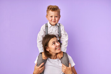 young caucasian woman holds her young son on neck. mother and little son have a good time. mother's day. concept of family