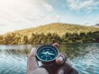 hand holding compass with nature background