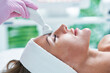 © Kalim - Adult woman in beauty salon undergoing face hydrogen purification