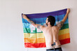 © Alberto Menendez/ADDICTIVE STOCK - young caucasian boy hanging a rainbow flag of peace in a white room.