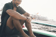 © Jorge Moya/ADDICTIVE STOCK - Positive young ethnic male in unbuttoned shirt and shorts enjoying summer day while resting on sandy beach near surfboard