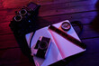 © Juan Garcia Risquez/ADDICTIVE STOCK - From above top view of black retro photo camera with notebook and film composed with vintage radio on wooden table in dark studio