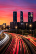 © Juan Lopez/ADDICTIVE STOCK - Drone view of cityscape with luminous highway in long exposure and skyscrapers under sunset sky
