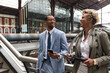 © Widetape/ADDICTIVE STOCK - Laughing elegant man and woman with papers and smartphone standing on bridge of railway station and chatting.