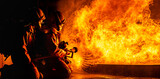 Fototapeta Desenie - Firefighters use twirl water fog spraying down fire flame.